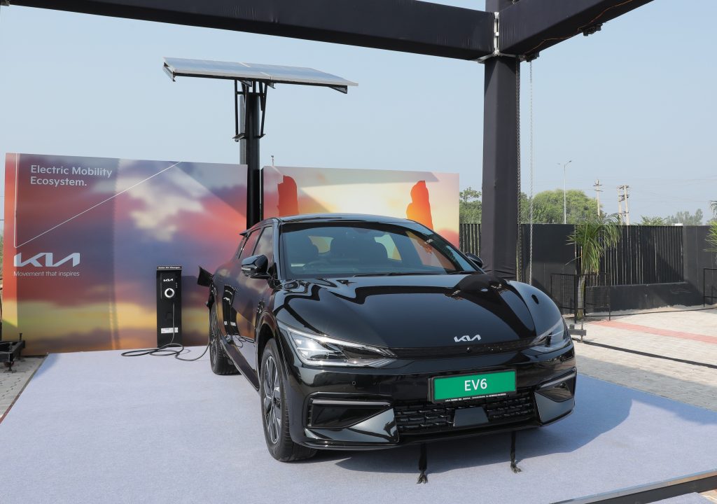 Kia EV6 electric car at a solar-powered charging station, showcasing Kia India's electric mobility ecosystem